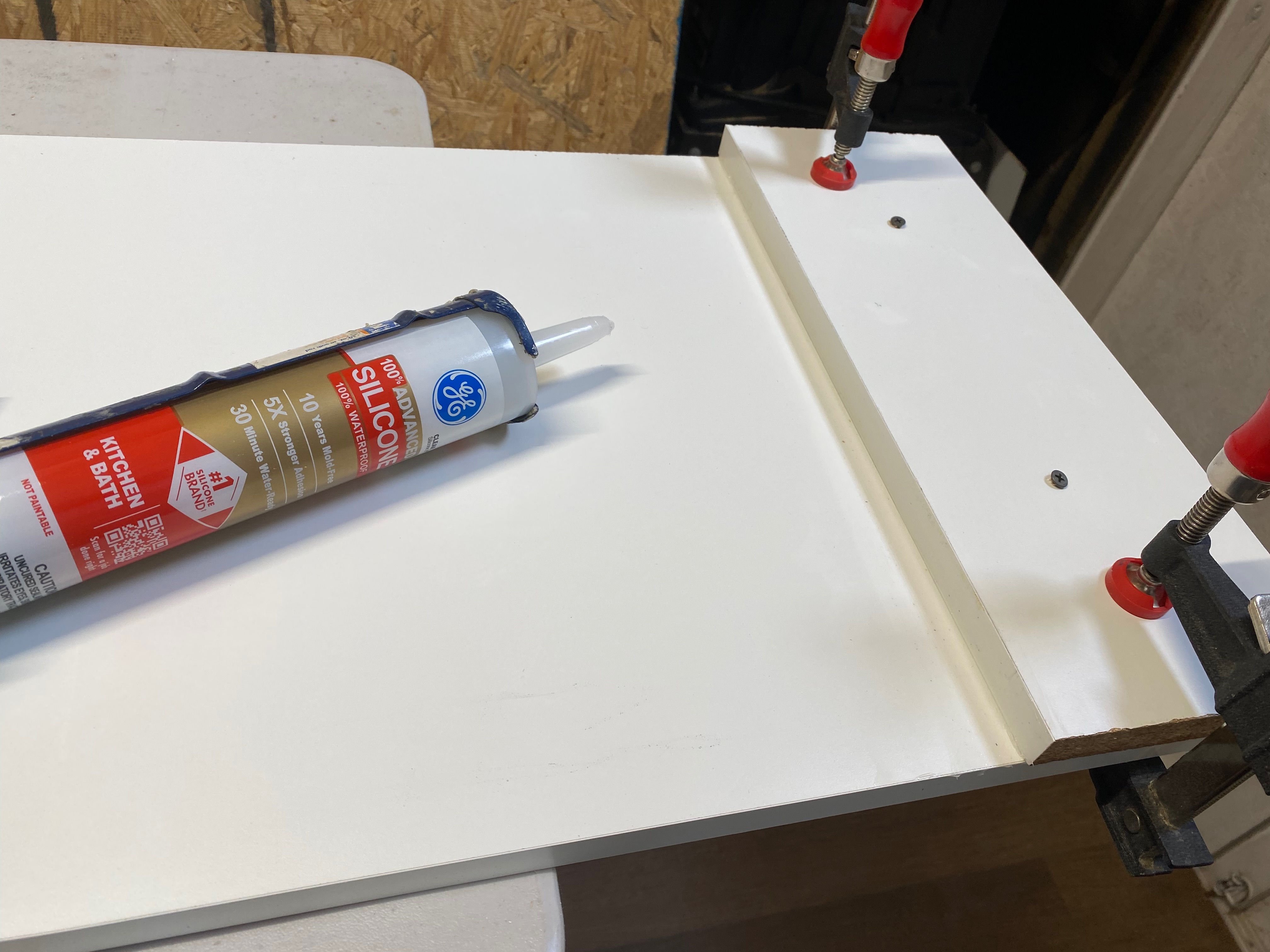 Second melamine layer screwed on top with silicone caulking.