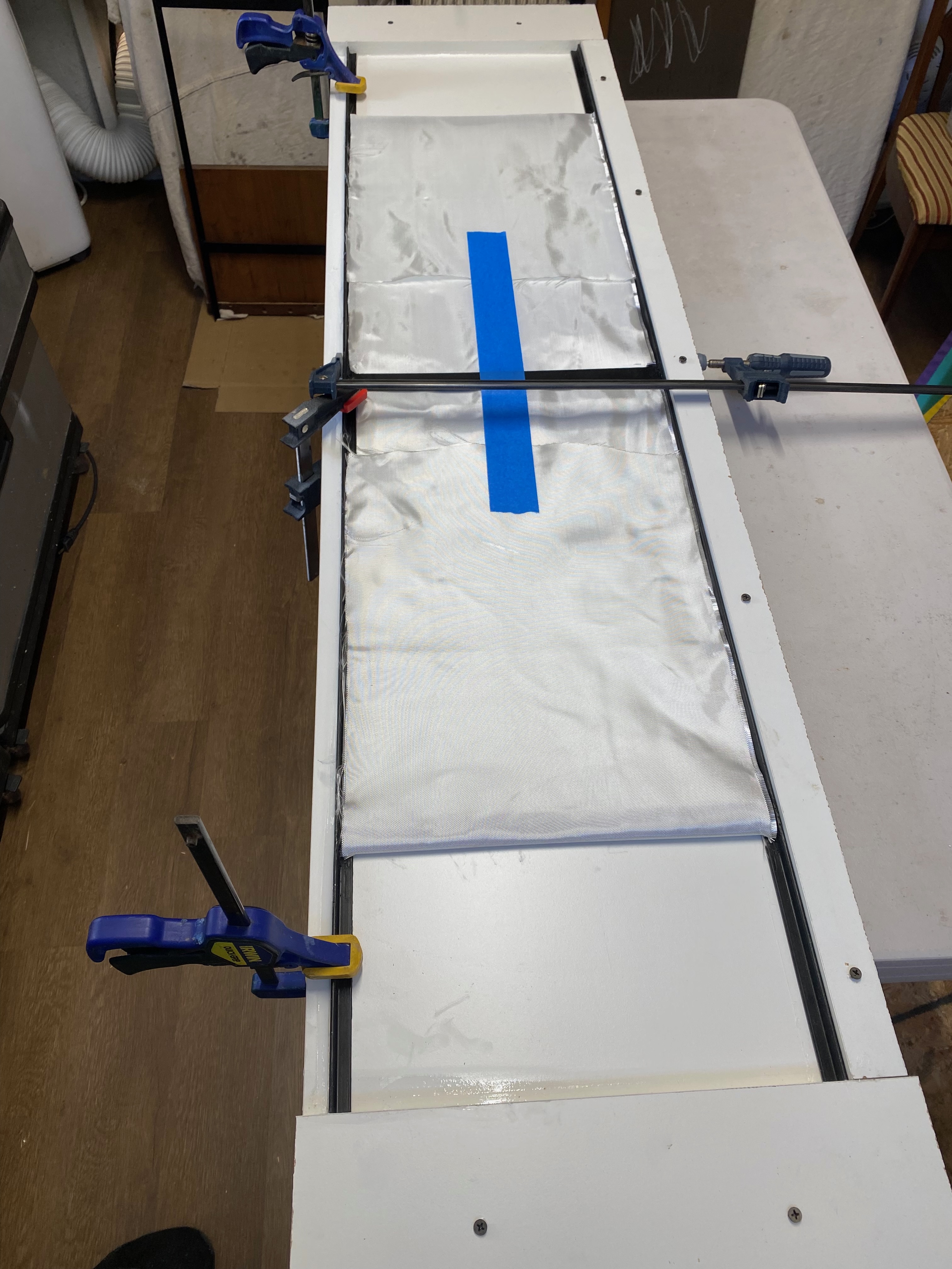 Panel in the mould with clamps straightening the long sides.